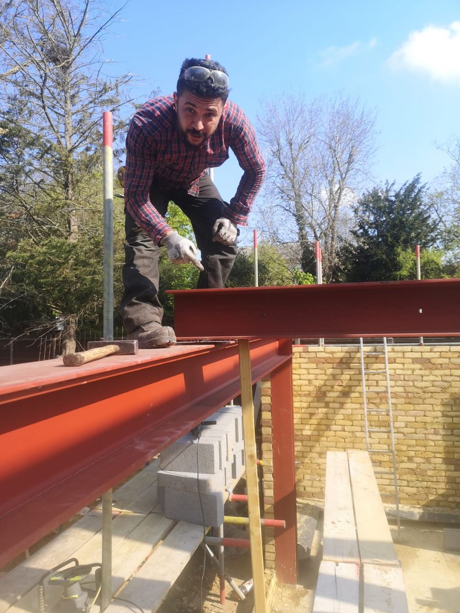 Coban Metal Works fabricator on site next to a steel beam