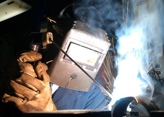 Welder from Coban Metal Works cutting through steel with arc sparks flying