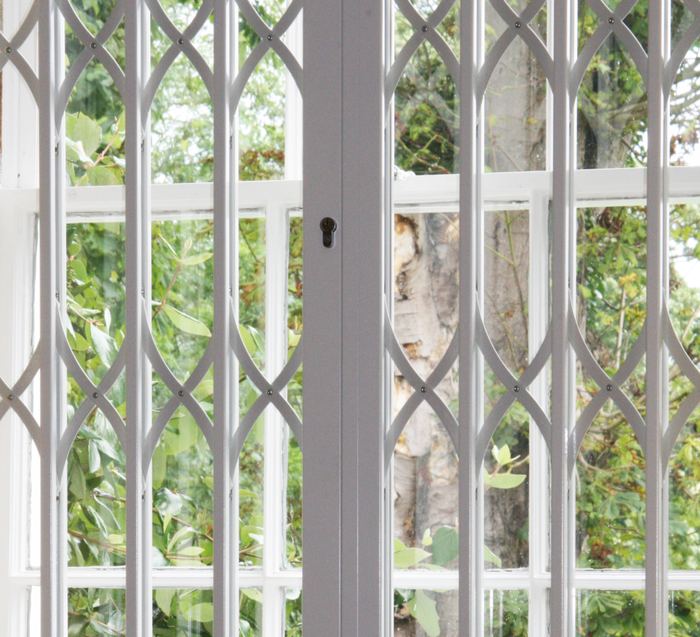 White decorative security grille fitted over a window